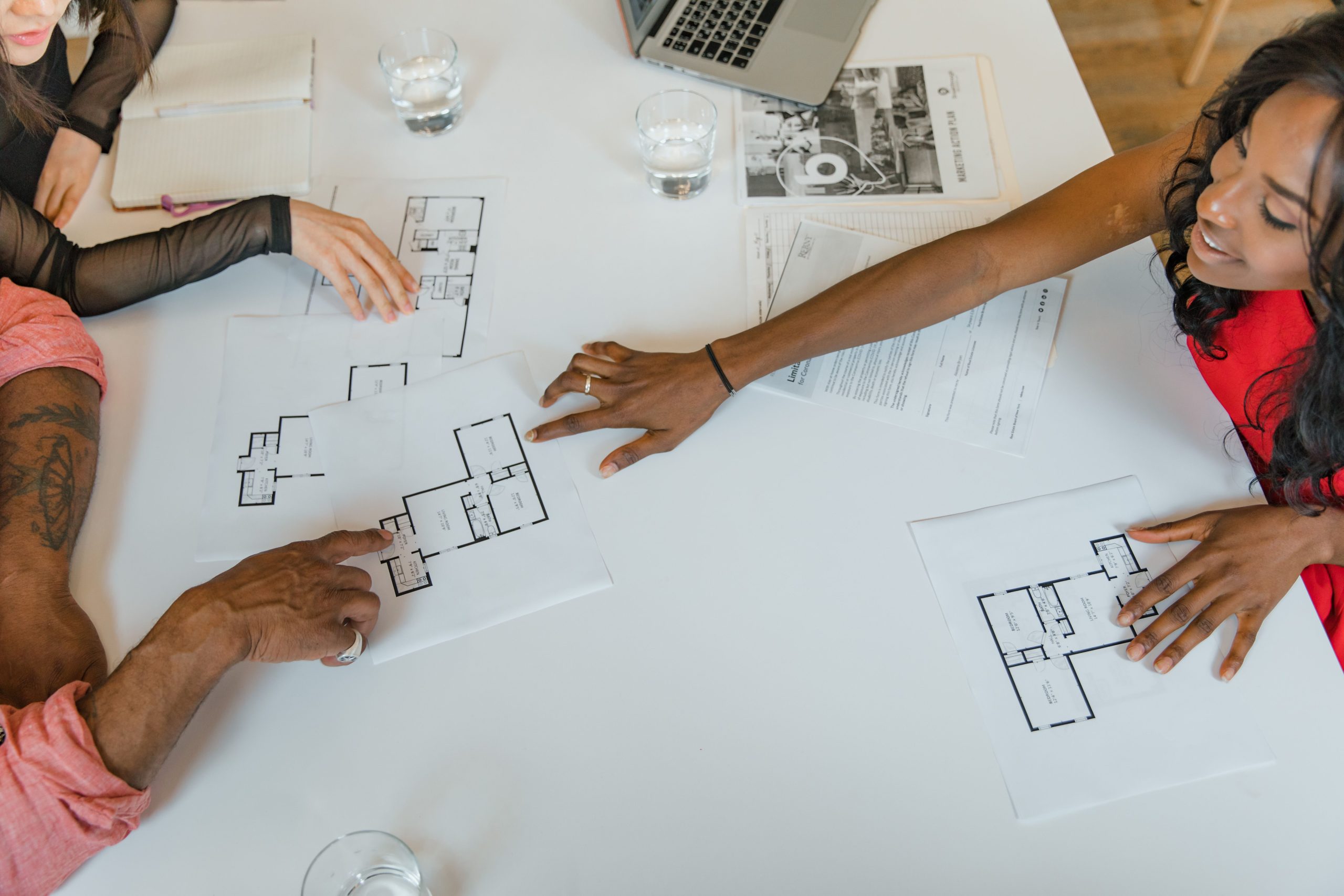 Équipe immobilière discutant plans architecturaux