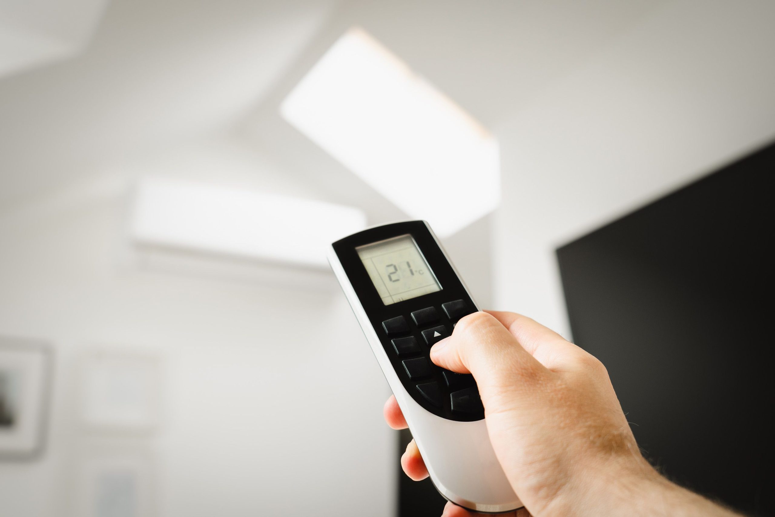 Homme utilisant télécommande climatisation