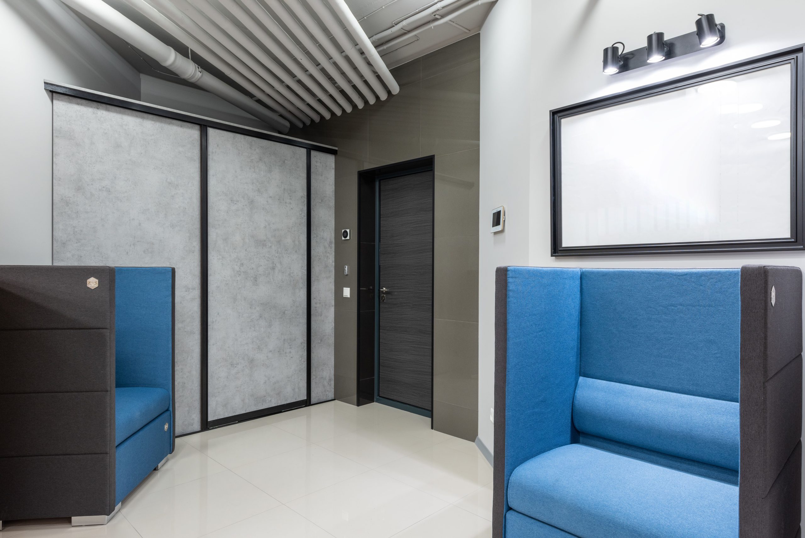 Lobby contemporain avec fauteuils bleus et armoire