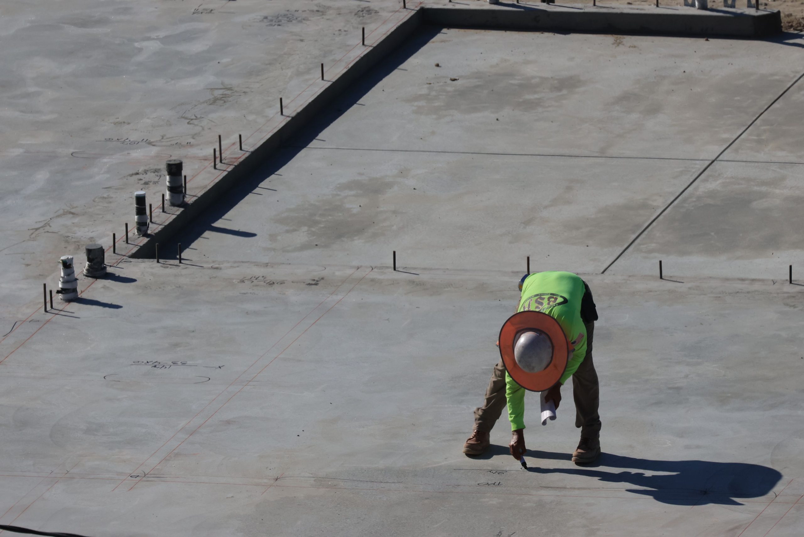 Ouvrier pliant sur dalle béton en chantier urbain