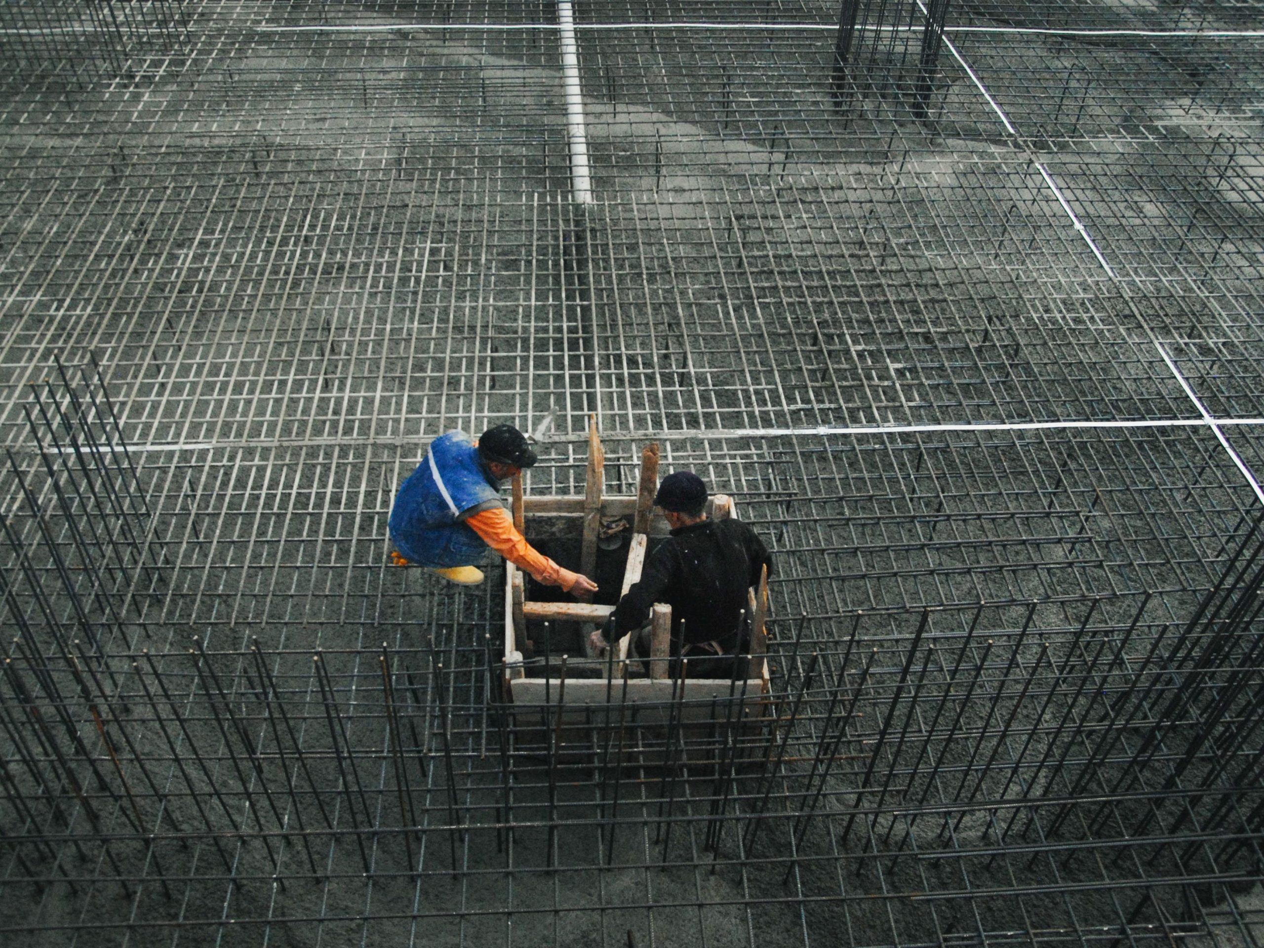 Deux ouvriers travaillant sur chantier dalle béton