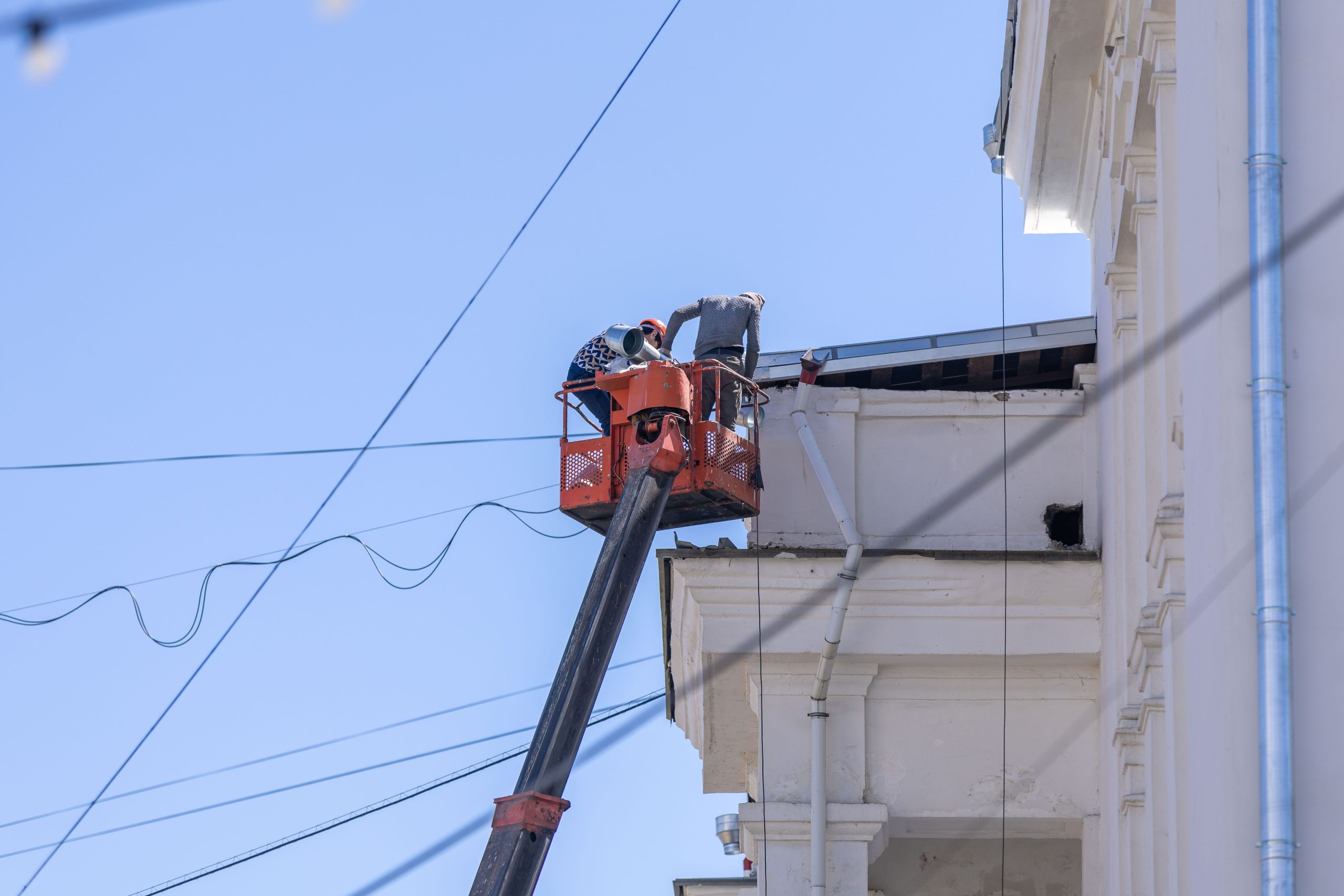 Ouvriers en plateforme réparant façade bâtiment